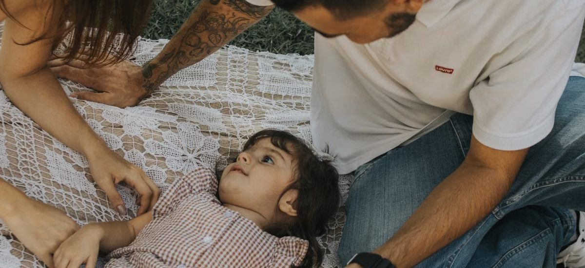 Relaxing family picnic with parents and child outdoors on a summer day.