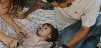 Relaxing family picnic with parents and child outdoors on a summer day.
