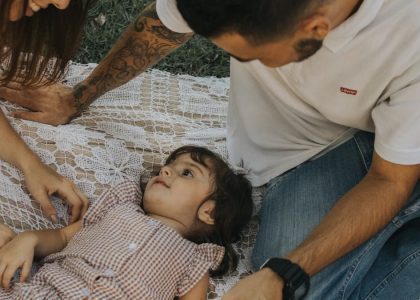 Relaxing family picnic with parents and child outdoors on a summer day.