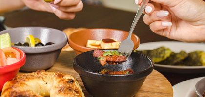 A delightful Middle Eastern breakfast spread featuring olives, bread, and various small dishes, showcasing vibrant flavors.